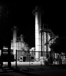 Illuminated factory against sky at night