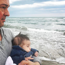 Rear view of father and son at beach