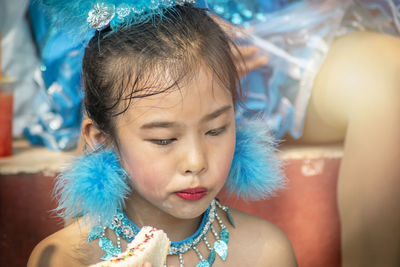 Close-up of cute girl in costume eating sandwich