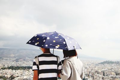 Rear view of man looking at cityscape