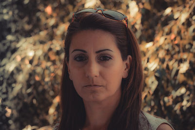 Close-up portrait of mature woman against trees