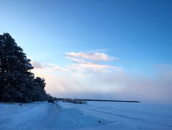 Snow covered field against sky