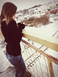 Woman standing on fence