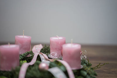 Close-up of candles and wreath on table during christmas