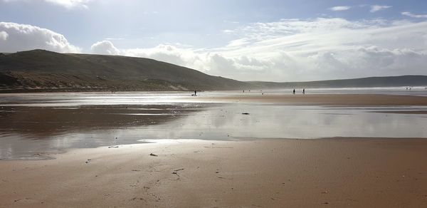 Scenic view of beach and mountains against sky