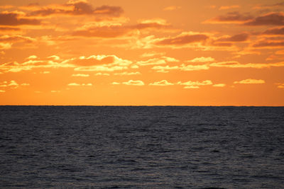 Scenic view of sea against orange sky