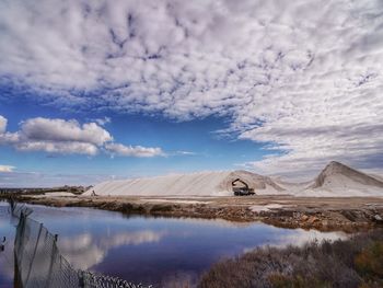 Scenic view of lake by mountain against sky