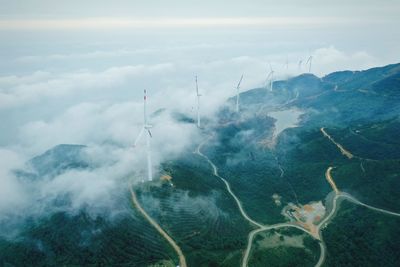 Aerial view of windmills on landscape against sky