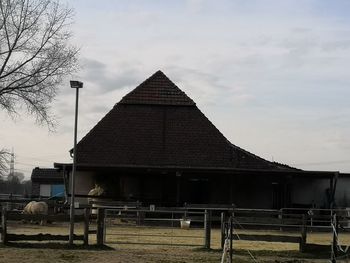 Built structure on field by building against sky