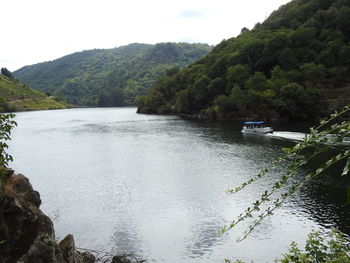 Scenic view of river amidst trees against sky