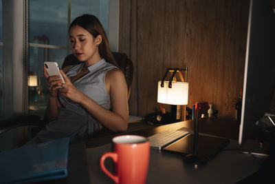 Cute girl using smart phone sitting at home