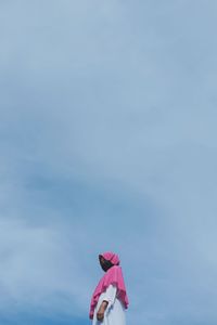Low angle view of pink umbrella against blue sky