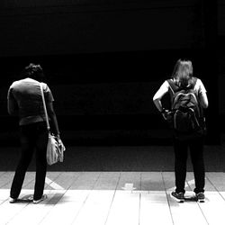 Rear view of a woman standing in the dark