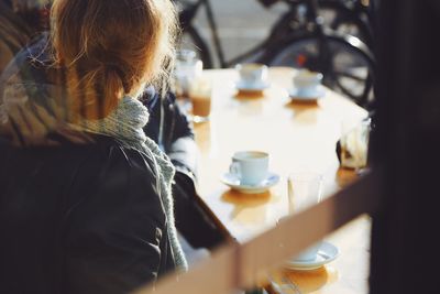 High angle view of woman sitting with drink in cafe