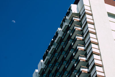 Low angle view of modern building against clear blue sky