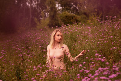 Woman with pink flowers on field