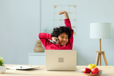 Woman using laptop while sitting on table