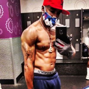 Full length of shirtless man holding mobile phone