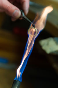 Close-up of hand holding burning candle