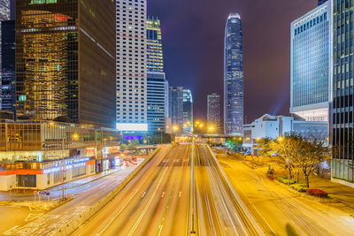 Light trails on road amidst buildings in city at night