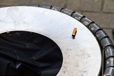 High angle view of cigarette butt on garbage bin