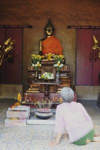 Buddha statue on table against building