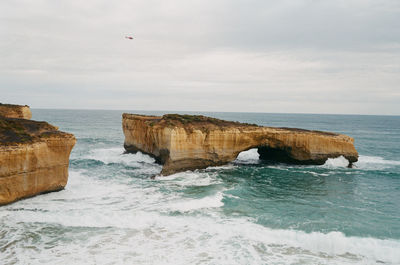 Scenic view of rocks in sea against sky