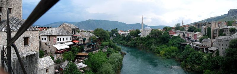 Panoramic view of village by town against sky