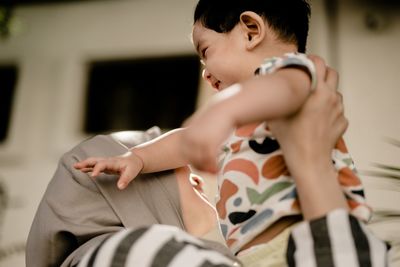 Mother carrying daughter at home