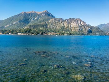 Scenic view of sea and mountains against clear sky