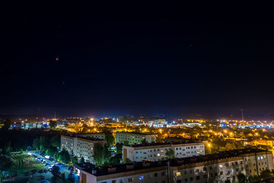 High angle view of illuminated buildings against sky at night