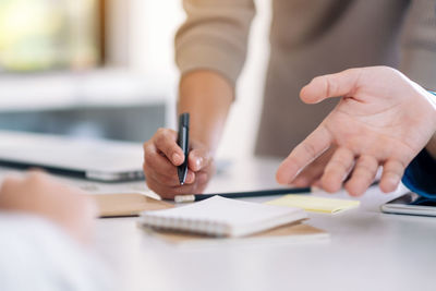 Cropped image of business people working at table