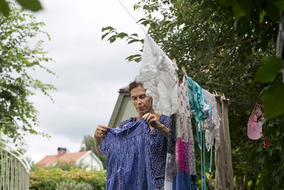 Mature woman hanging laundry, stockholm, sweden