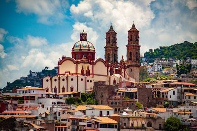 View of buildings in city against cloudy sky