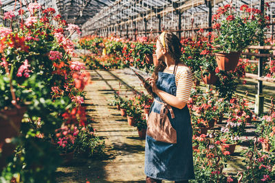 Rear view of woman standing amidst plants