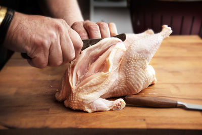 Close-up of hand holding bread on cutting board