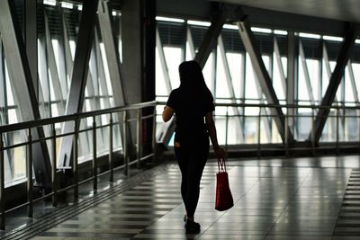 Rear view of silhouette man walking in building