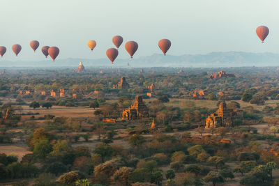 Hot air balloons flying over landscape against sky