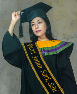 Portrait of woman standing against wall