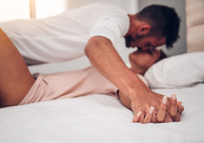 Midsection of man relaxing on bed