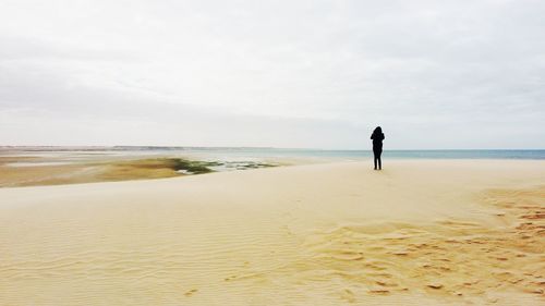 Full length of man standing on beach against sky