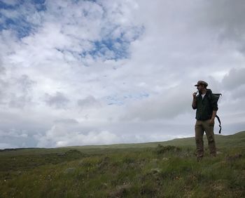 Man photographing on field against sky