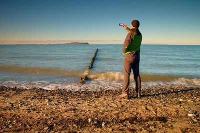 Rear view of man standing on beach