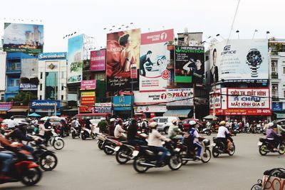 People on road against sky in city