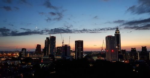 Panoramic view of illuminated buildings in city against sky