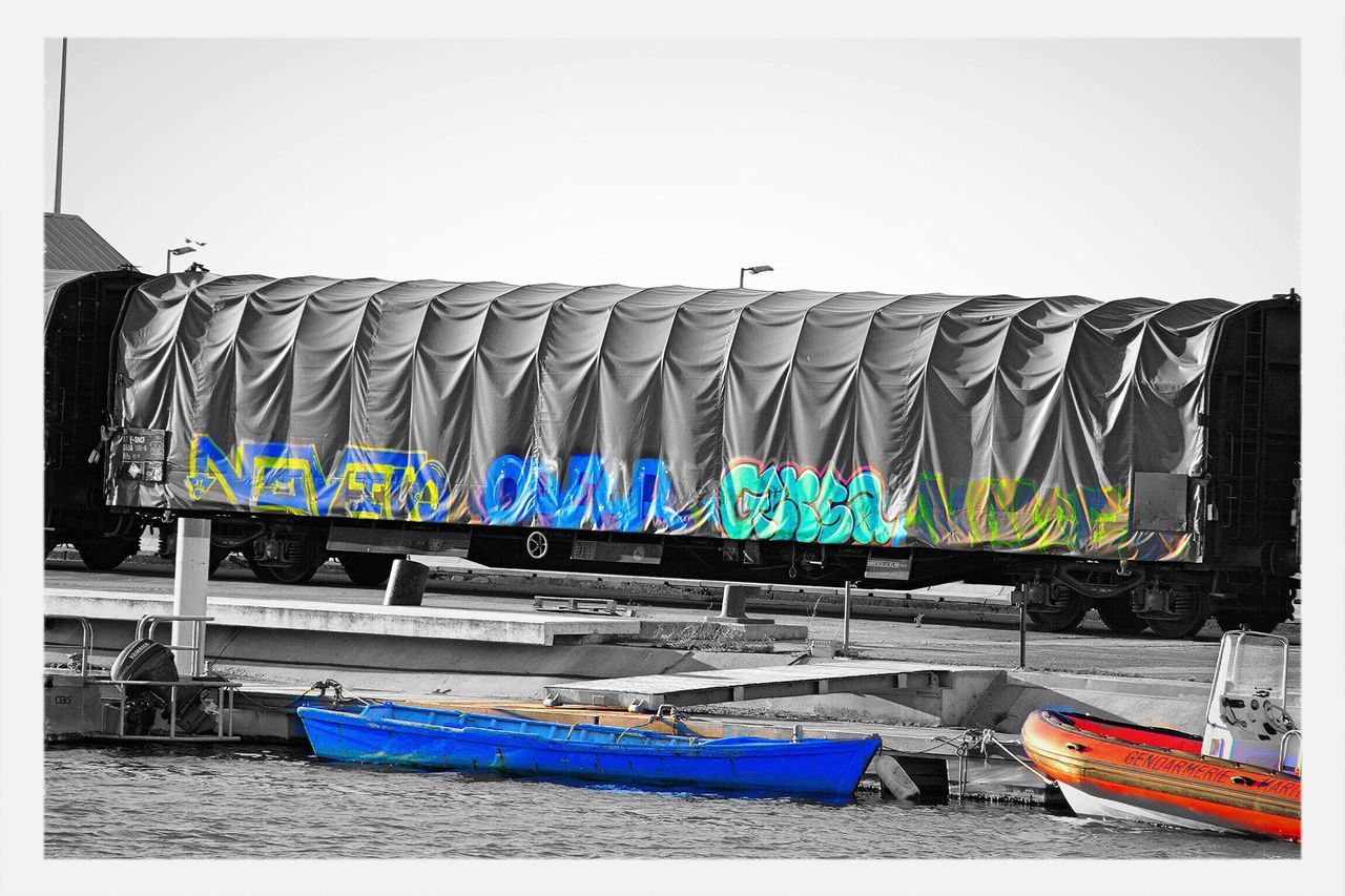 blue, multi colored, nautical vessel, built structure, transportation, day, architecture, copy space, boat, auto post production filter, wall - building feature, mode of transport, transfer print, clear sky, moored, no people, outdoors, wall, absence, graffiti