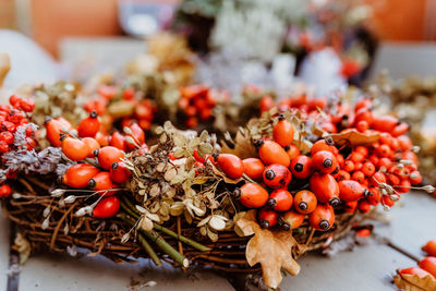 Handmade colorful floral autumn door wreath made of colorful rosehip berries, rowan, dry flowers 