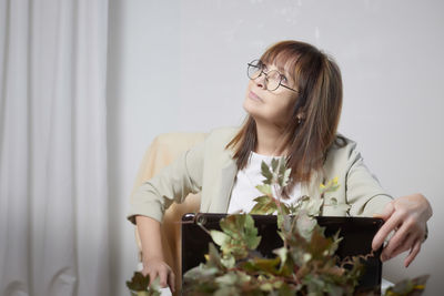 Young woman using mobile phone while sitting at home