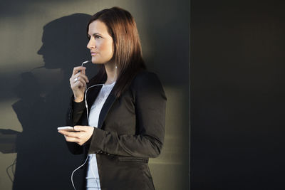 Young businesswoman talking on headphones in office