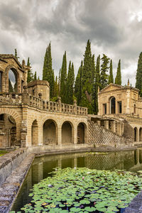 Built structure by lake against sky